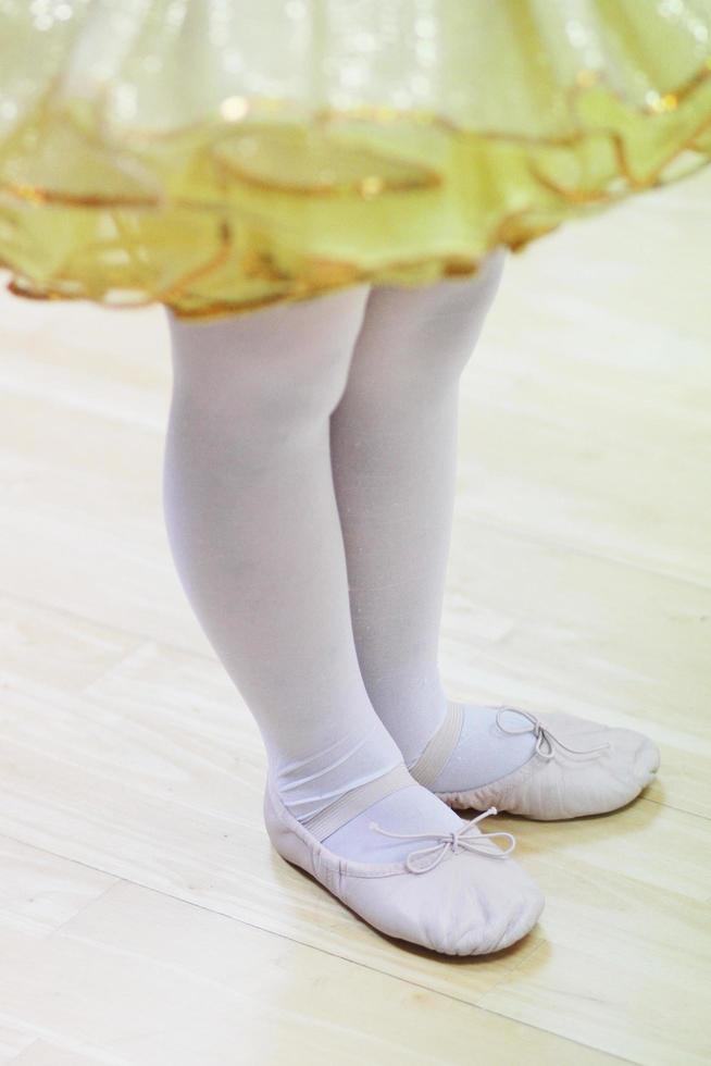 Little girls in yellow ballet tutu dress and pink ballet shoes. photo