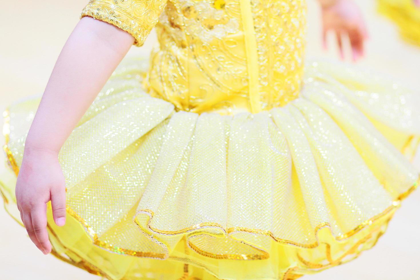 Little girls in yellow ballet tutu dress and pink ballet shoes. photo