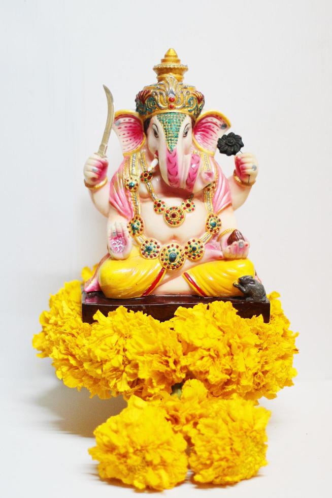 Ganesha god is the Lord of Success God of Hinduism on Marigold flowers Isolated on white background. photo