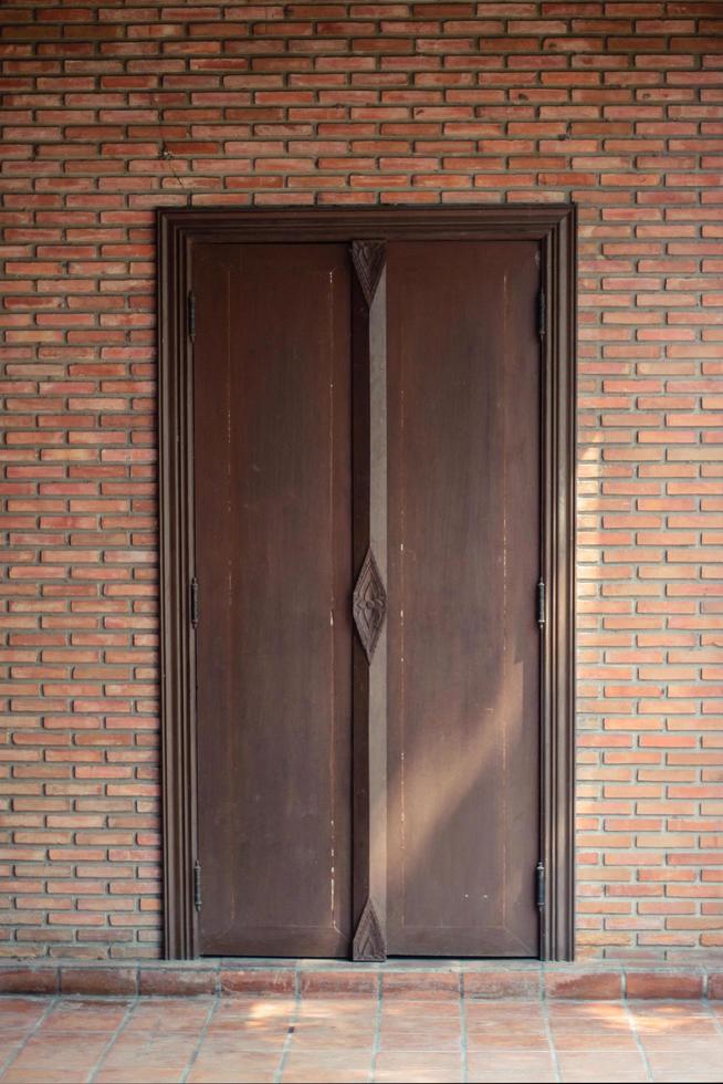 Sunshine through on Antique thai style wooden window on brick wall. Vintage concept. photo