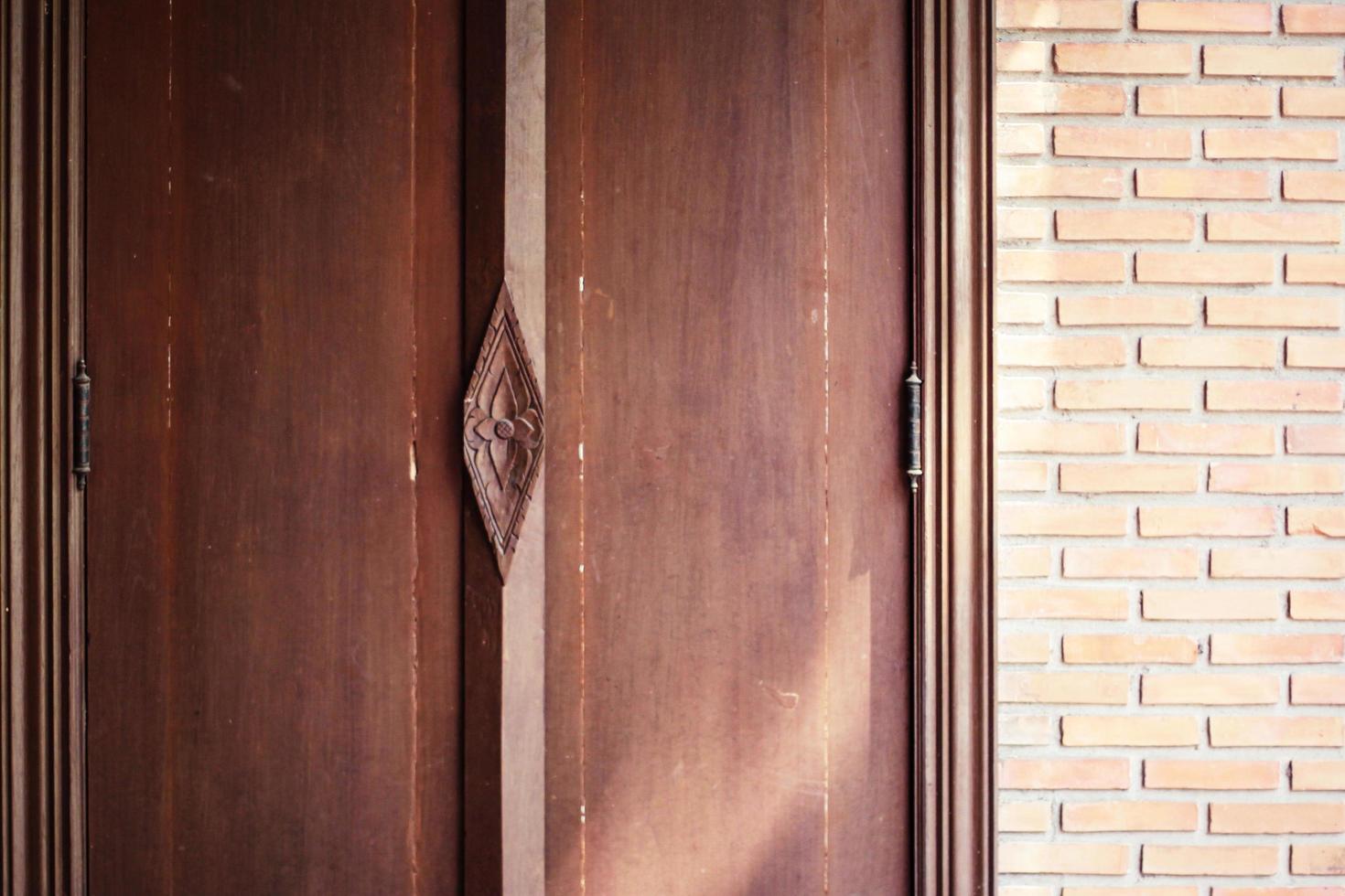 Sunshine through on Antique thai style wooden window on brick wall. Vintage concept. photo