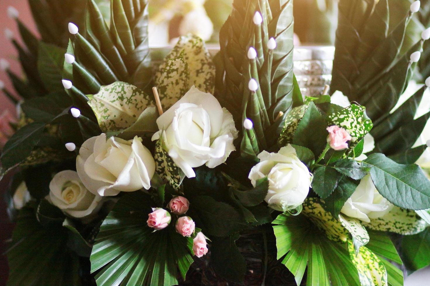 Beautiful blooming White Rose Flowers in vase made of banana leaf in Traditional Thai Art  Decorated Craft Pattern in wedding ceremony traditional. photo