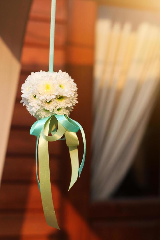 White bouquet flowers with ribbon hanging decoration in wedding ceremony photo