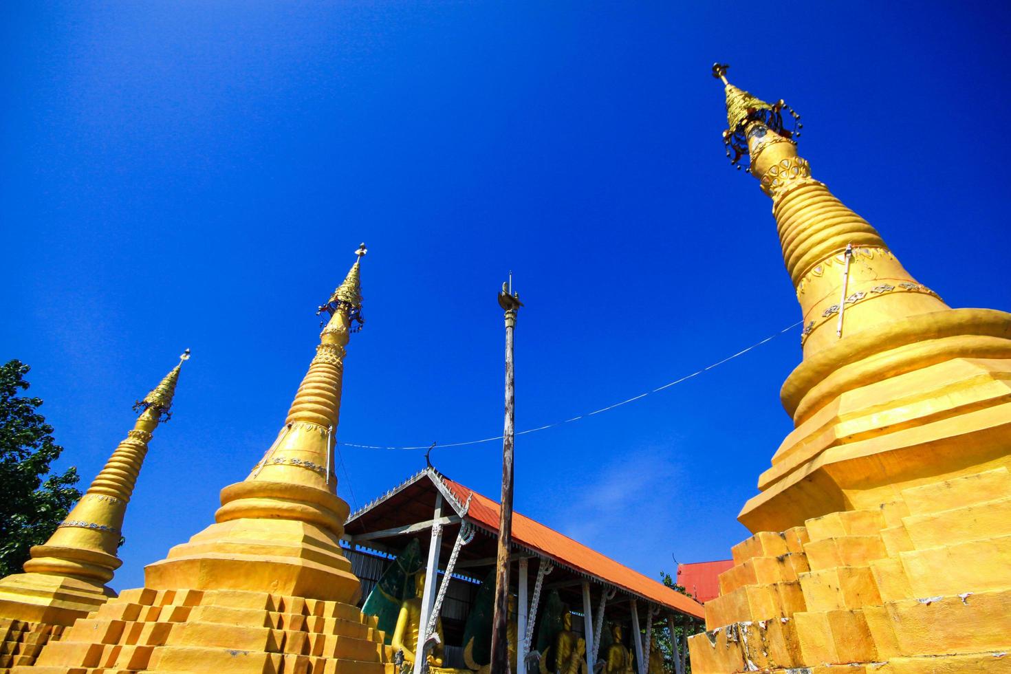 Golden pagoda detail is Mon architectural style at temple located in Kanchanaburi Province, Thailand. photo