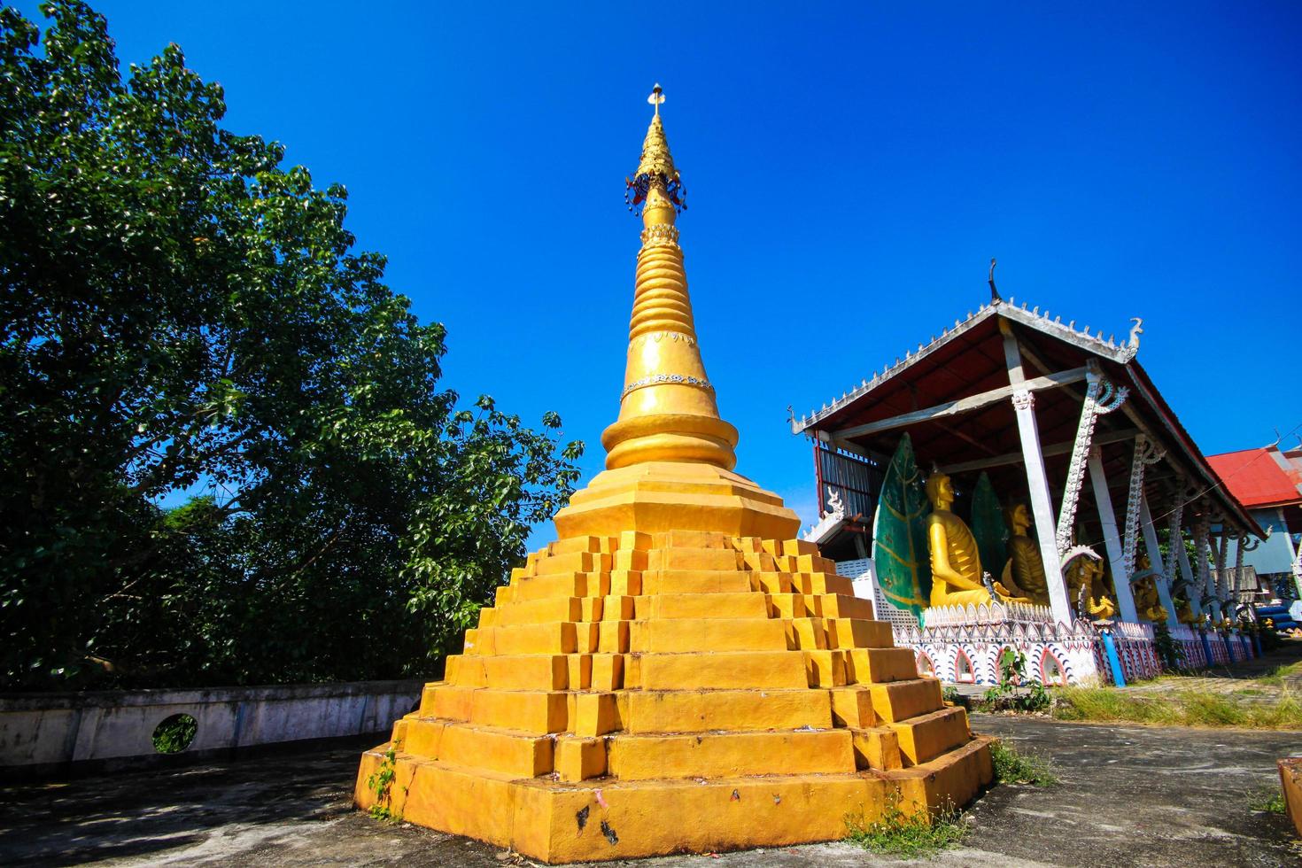 Golden pagoda detail is Mon architectural style at temple located in Kanchanaburi Province, Thailand. photo