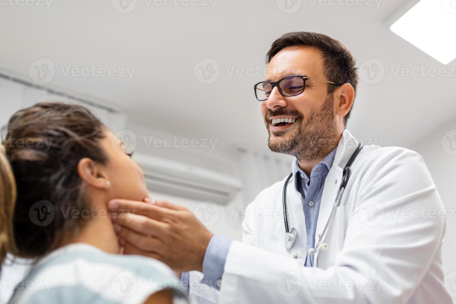 medicamento, cuidado de la salud y médico examen concepto - médico comprobación del paciente anginas a hospital. endocrinólogo examinando garganta de joven mujer en clínica foto