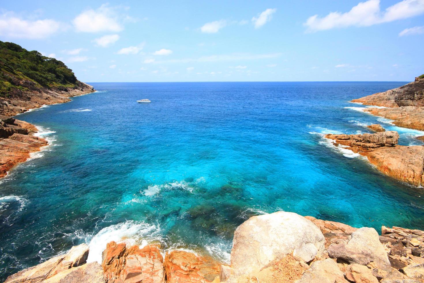 Beautiful paradise in summer of seascape and sea horizon with yacht boat in Calm ocean and blue sky on rock mountain Cape.Tropical Beach plants and jungle island photo