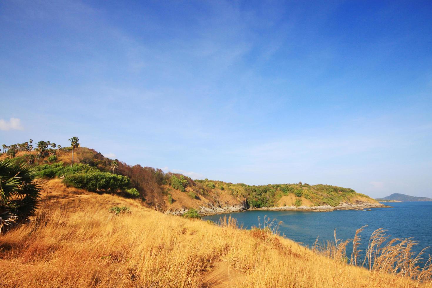 Beautiful seascape with sky twilight of sunset and sea horizon with Calm and blue sky.Dry grass field on mountain of Phrom Thep Cape is famous place in Phuket island, Thailand. photo