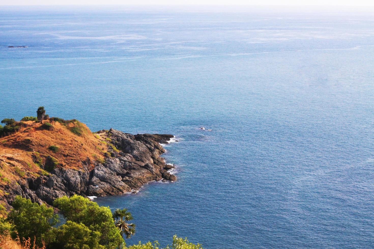 Beautiful seascape with sky twilight of sunset and sea horizon with Calm and blue sky.Dry grass field on mountain of Phrom Thep Cape is famous place in Phuket island, Thailand. photo