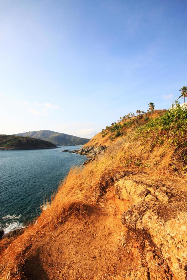 Beautiful seascape with sky twilight of sunset and sea horizon with Calm and blue sky.Dry grass field on mountain of Phrom Thep Cape is famous place in Phuket island, Thailand. photo