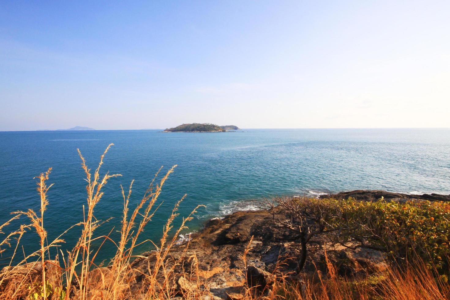 Beautiful seascape with sky twilight of sunset and sea horizon with Calm and blue sky.Dry grass field on mountain of Phrom Thep Cape is famous place in Phuket island, Thailand. photo