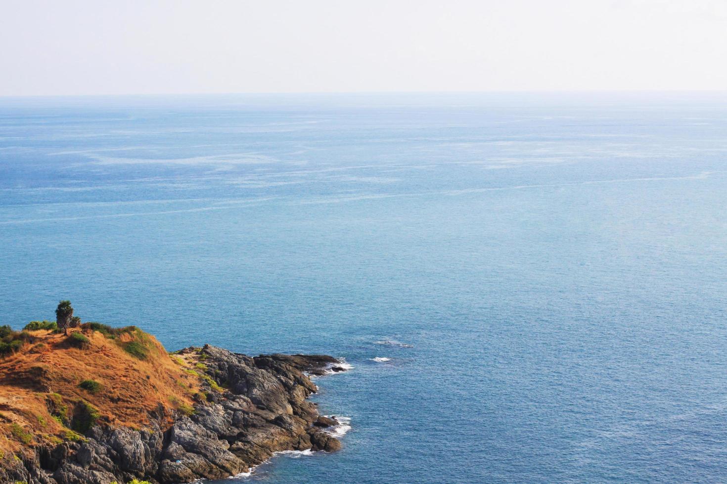 Beautiful seascape with sky twilight of sunset and sea horizon with Calm and blue sky.Dry grass field on mountain of Phrom Thep Cape is famous place in Phuket island, Thailand. photo