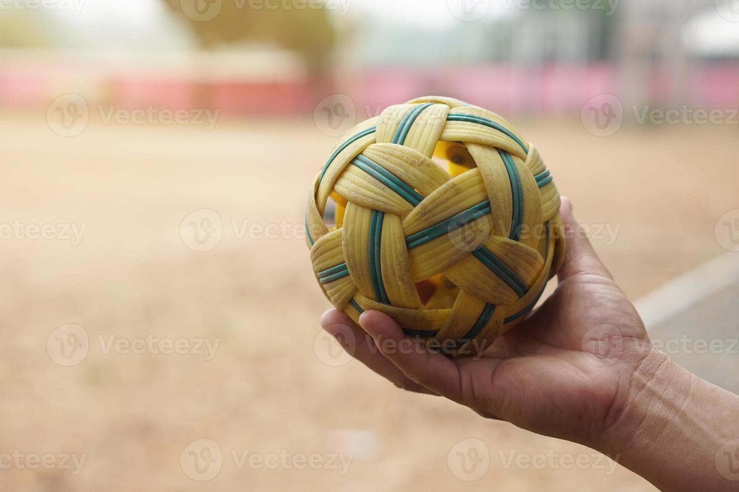 Closeup man hold Sepak Takraw ball outdoor. Concept, Asian traditional sport. A ball made of rattan or synthetic plastic. Sport with equipment that can play for outdoor or indoor. Competitive game. photo