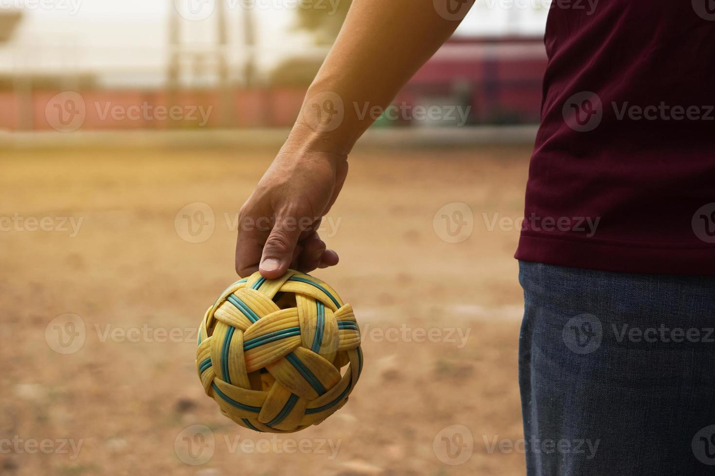 Closeup man hold Sepak Takraw ball outdoor. Concept, Asian traditional sport. A ball made of rattan or synthetic plastic. Sport with equipment that can play for outdoor or indoor. Competitive game. photo