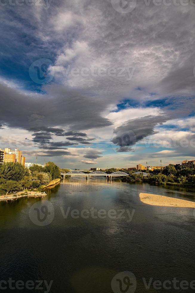 landscape in a spring day over the city bridge and the Ebro river in the Spanish city of Zaragoza photo