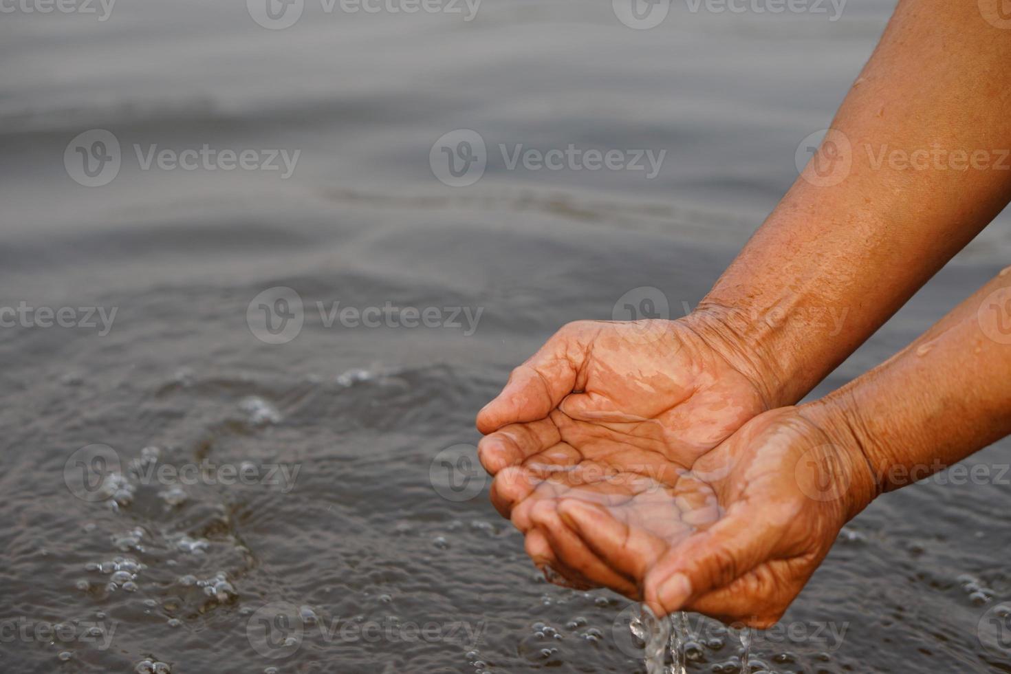 Closeup hands hold some water in river. Concept, explore, inspect clarify and quality of water from natural source. Ecology survey. Environment conservation. photo