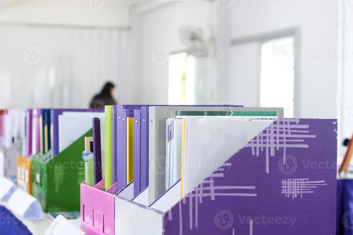 Colorful folders of personnel and office staff are kept and sorted in boxes in the office to evaluate their performance in order to raise their salary or increase their annual remuneration. photo