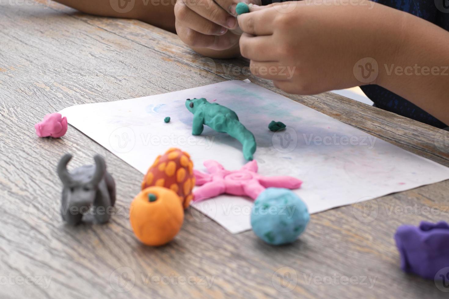 An autistic boy molding different shapes of colored plasticine prepared by parents at home in order to develop various aspects in their son which has slower brain development than normal children. photo