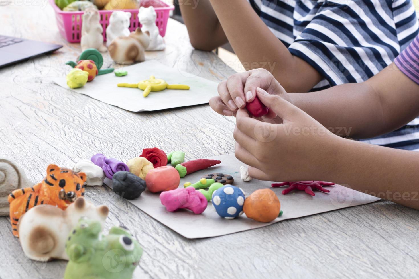 An autistic boy molding different shapes of colored plasticine prepared by parents at home in order to develop various aspects in their son which has slower brain development than normal children. photo