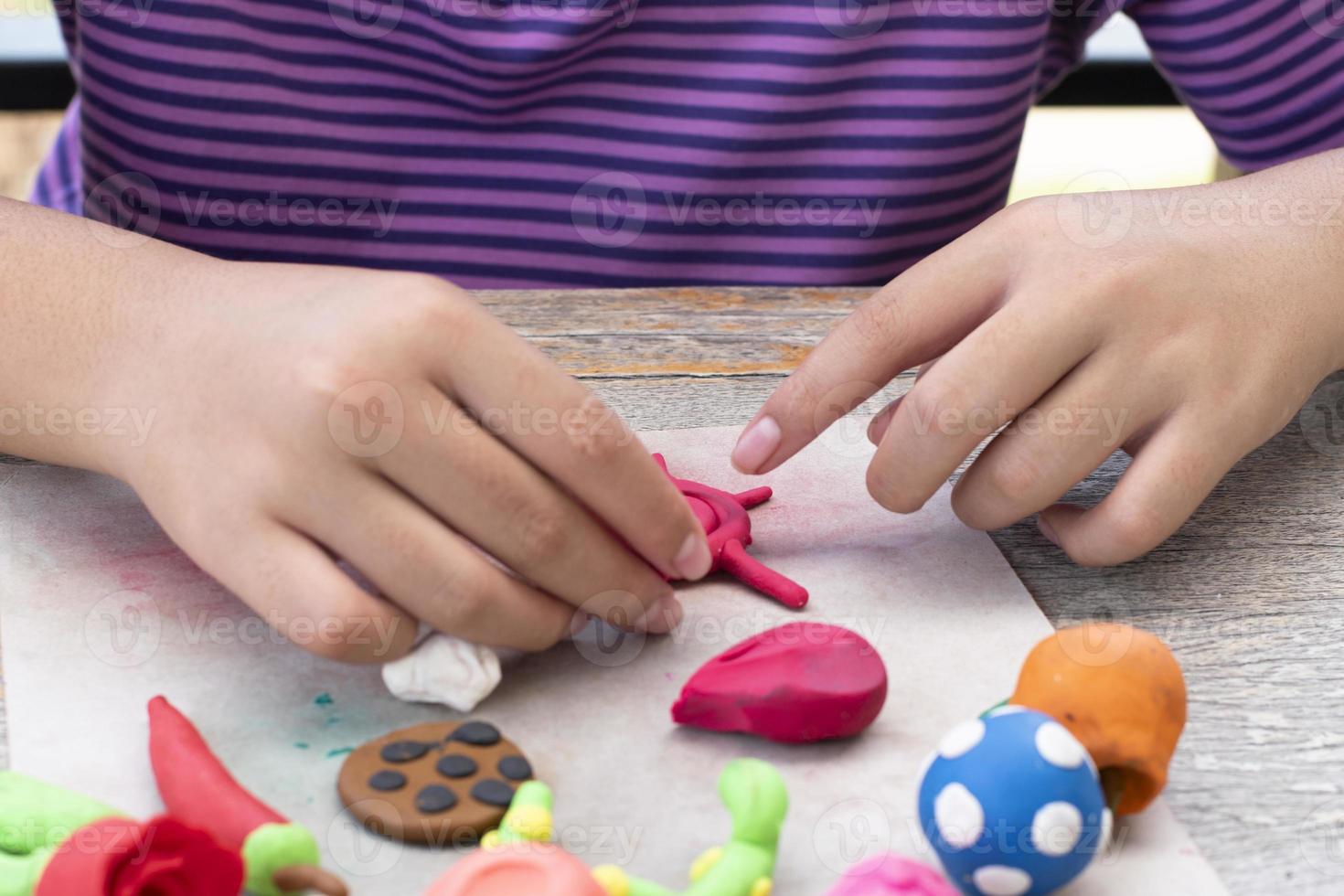 An autistic boy molding different shapes of colored plasticine prepared by parents at home in order to develop various aspects in their son which has slower brain development than normal children. photo