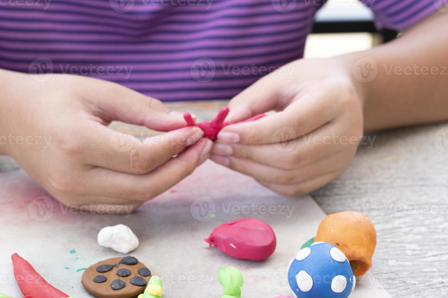 An autistic boy molding different shapes of colored plasticine prepared by parents at home in order to develop various aspects in their son which has slower brain development than normal children. photo