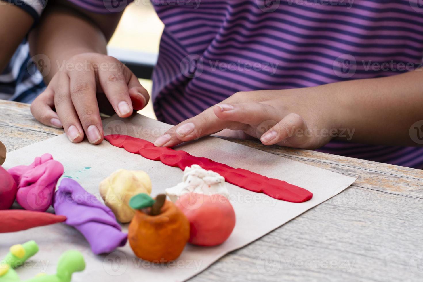 An autistic boy molding different shapes of colored plasticine prepared by parents at home in order to develop various aspects in their son which has slower brain development than normal children. photo