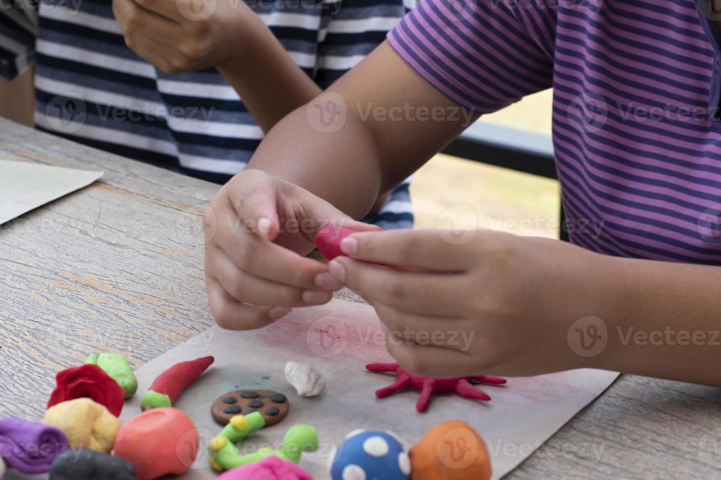 An autistic boy molding different shapes of colored plasticine prepared by parents at home in order to develop various aspects in their son which has slower brain development than normal children. photo