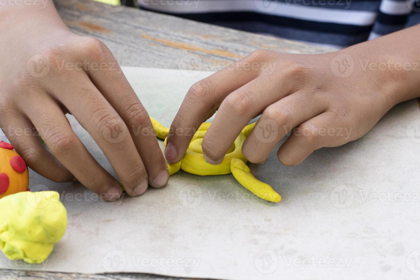 An autistic boy molding different shapes of colored plasticine prepared by parents at home in order to develop various aspects in their son which has slower brain development than normal children. photo