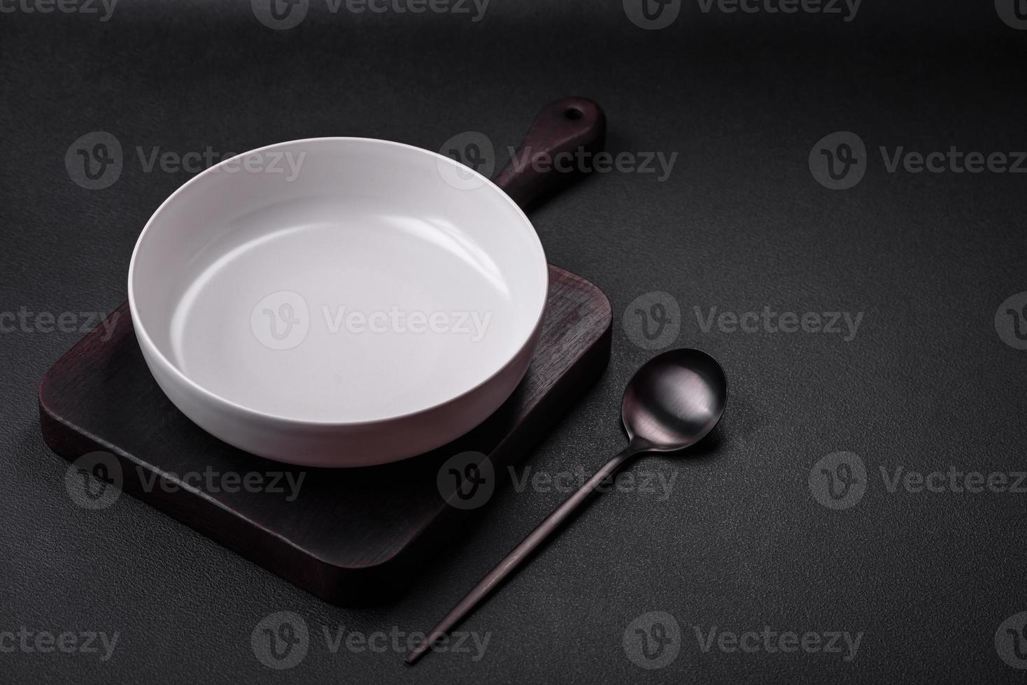 White empty soup bowl on a dark concrete background photo