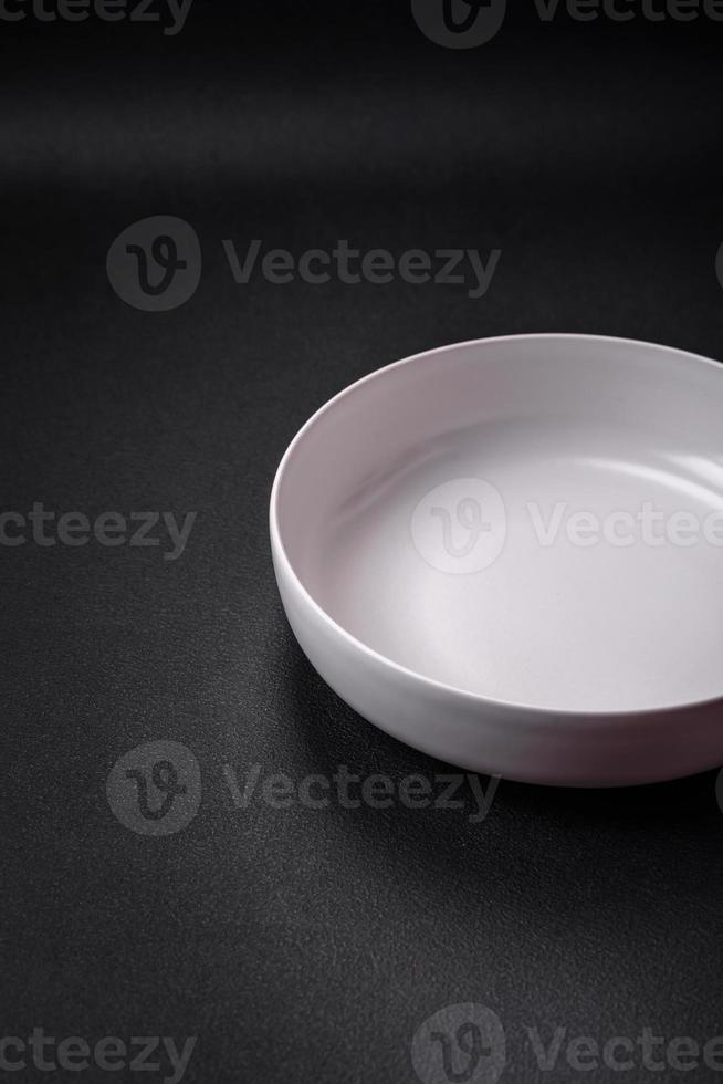 White empty soup bowl on a dark concrete background photo