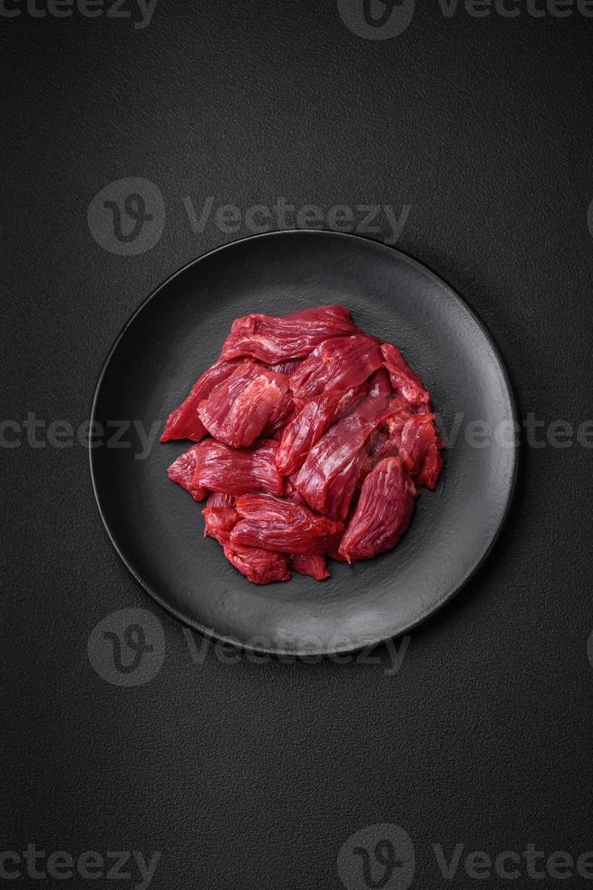 Fresh raw beef with salt, spices and herbs photo