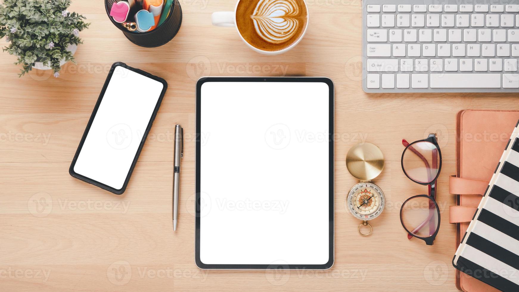 Office desk workplace with blank screen smartphone and tablet, keyboard, pen, eyeglass, notebook and cup of coffee, Top view flat lay with copy space photo