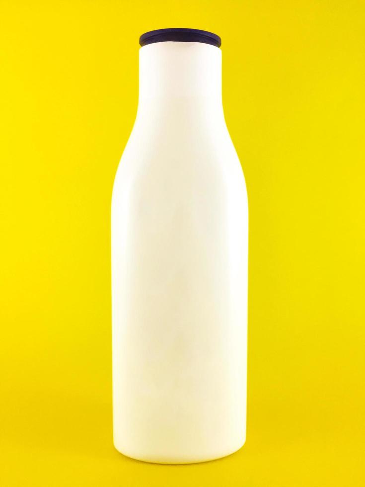 white beauty lotion bottle without label on a yellow background photo