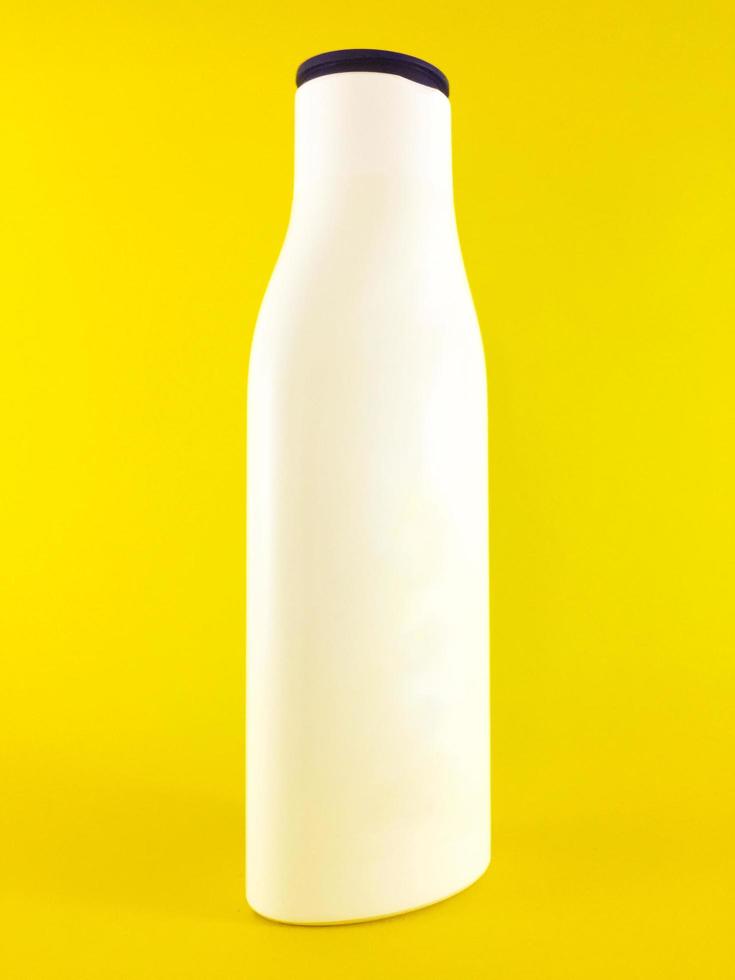 white beauty lotion bottle without label on a yellow background photo