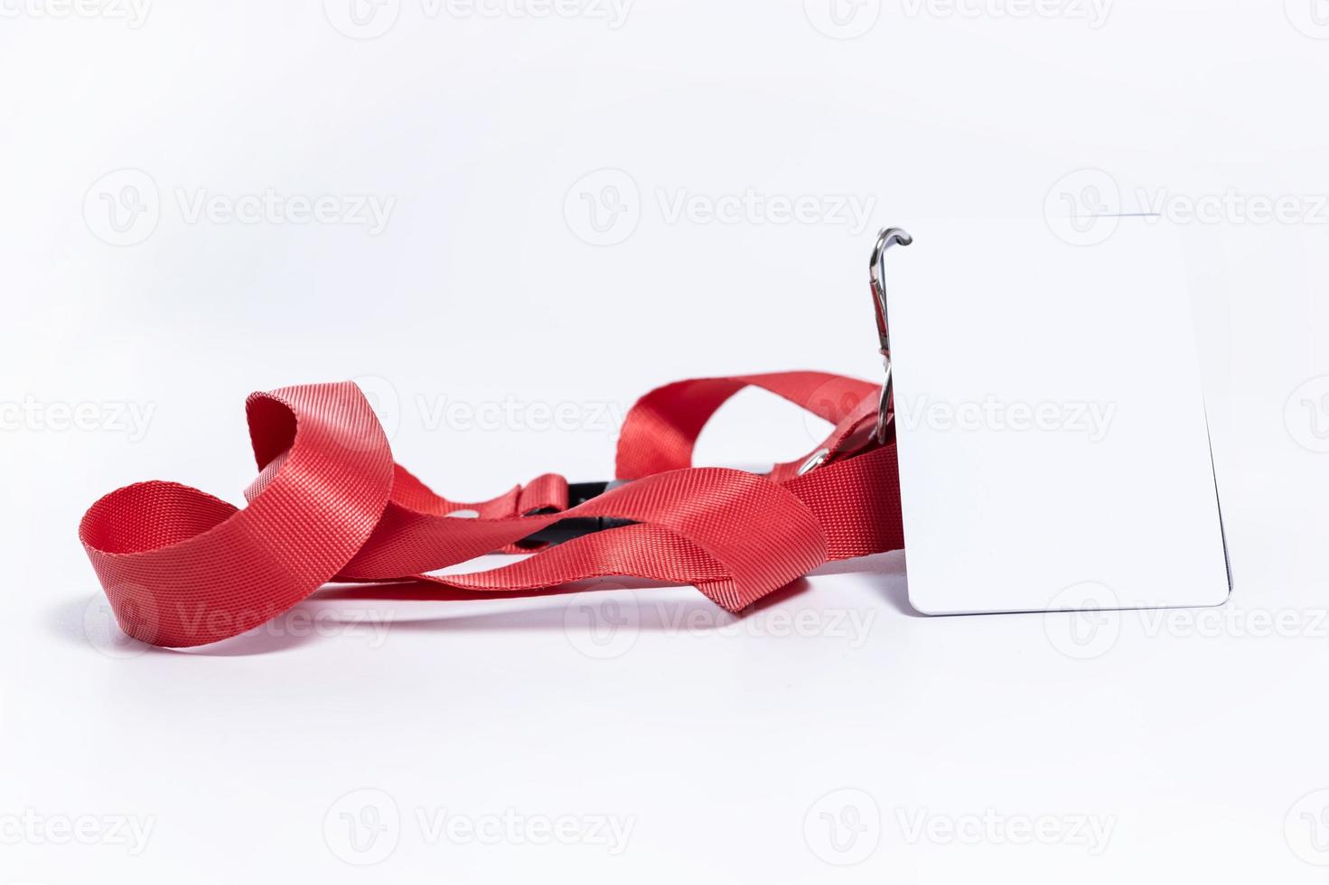 an empty white badge with a red belt stands on a white surface. badge mockup on white horizontal background photo