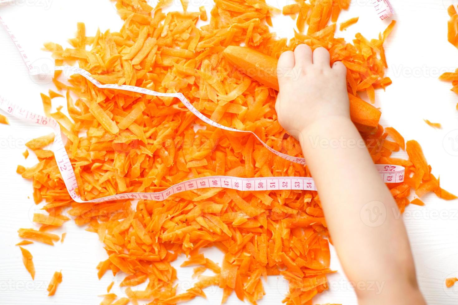chopped carrots on a white background. child takes a carrot. photo