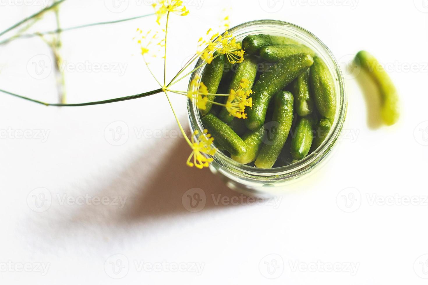 jar with pickled cucumbers on a white background. gherkins cucumbers. photo
