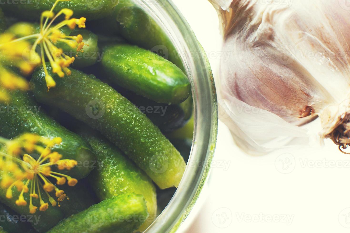 jar with pickled cucumbers on a white background. gherkins cucumbers top view photo