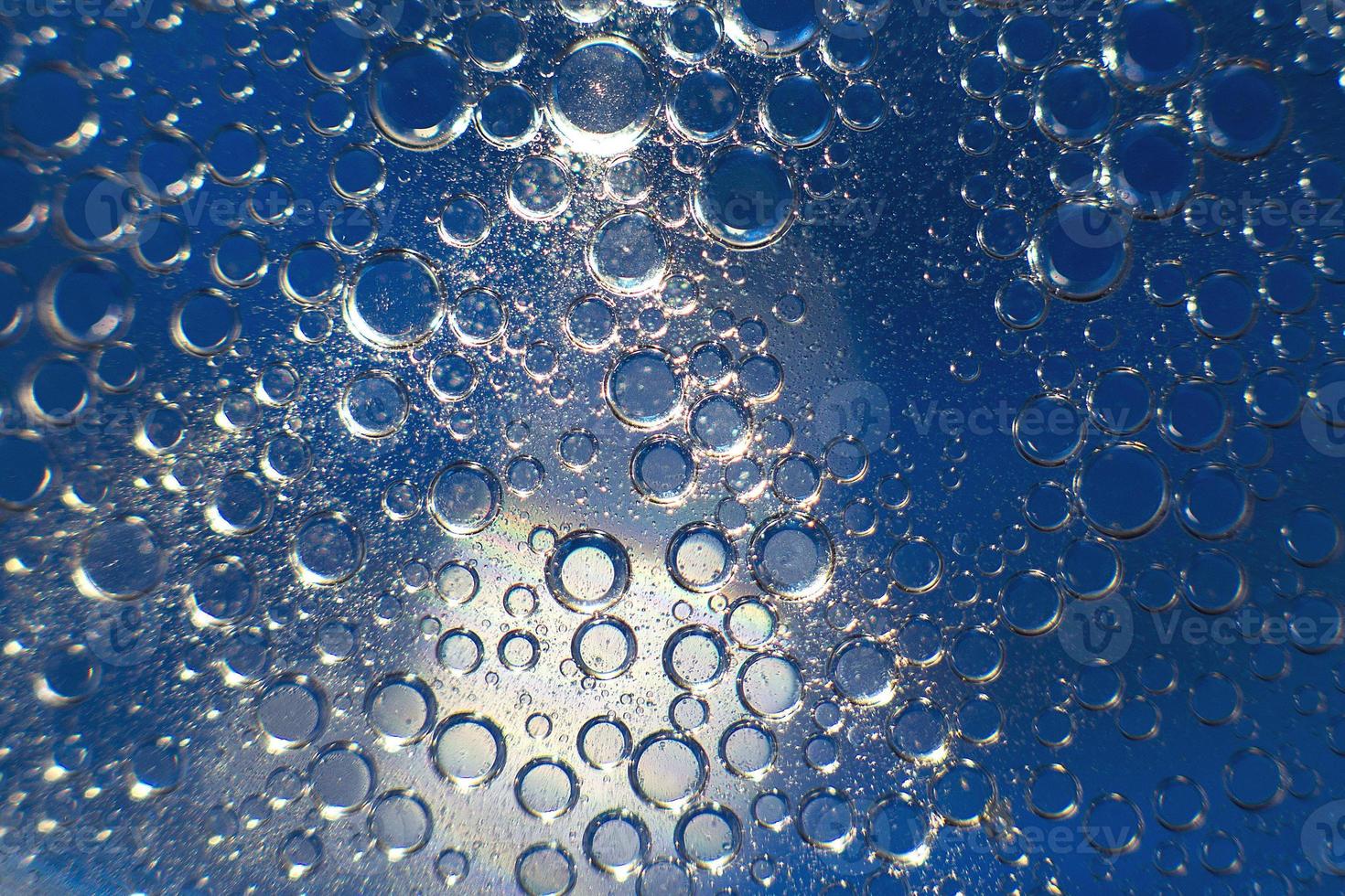 abstract light blue background with oil circles .  bubbles of water close up . oil bubbles in the water macro.  circle bubbles  background photo