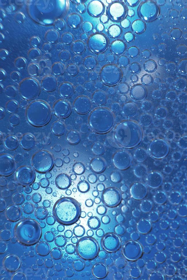 abstract light blue background with oil circles . bubbles of water close up . oil bubbles in the water macro. circle bubbles background photo