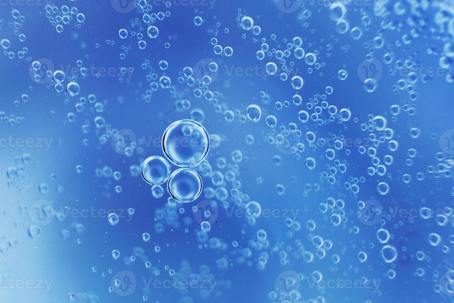 abstract light blue background with oil circles . bubbles of water close up . oil bubbles in the water macro. circle bubbles background photo