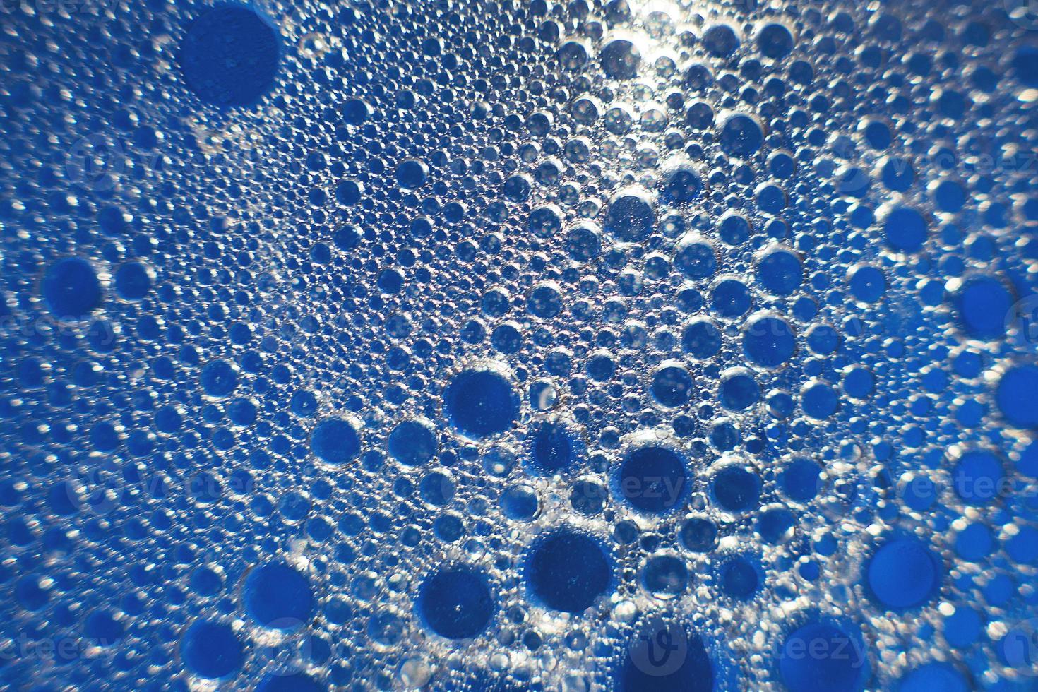 abstract light blue background with oil circles . bubbles of water close up . oil bubbles in the water macro. circle bubbles background photo