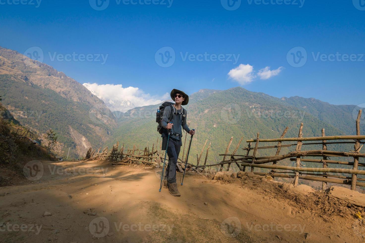 A young traveller trekking on forest trail , Nepal photo