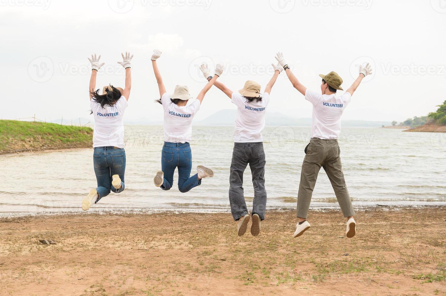 voluntarios desde el asiático juventud comunidad utilizando basura pantalones limpieza arriba naturaleza par foto