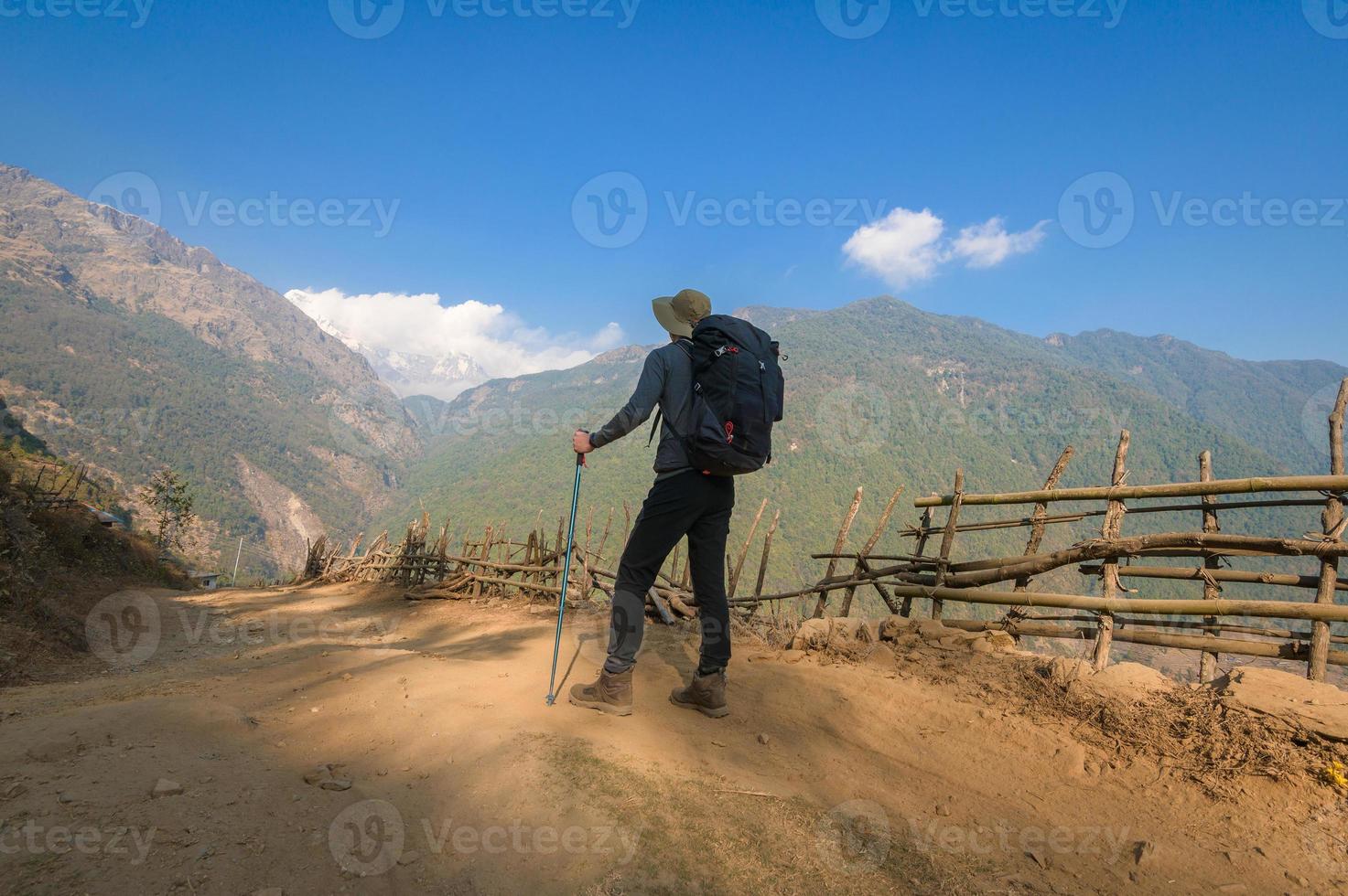 A young traveller trekking on forest trail , Nepal photo