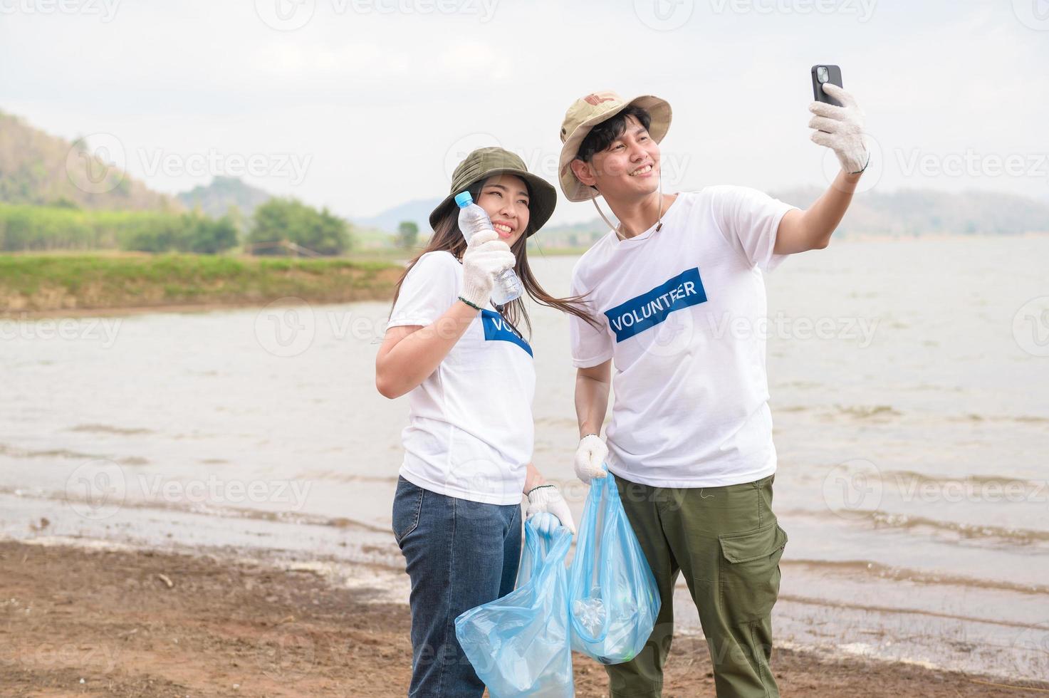 voluntarios desde el asiático juventud comunidad utilizando basura pantalones limpieza arriba naturaleza par foto