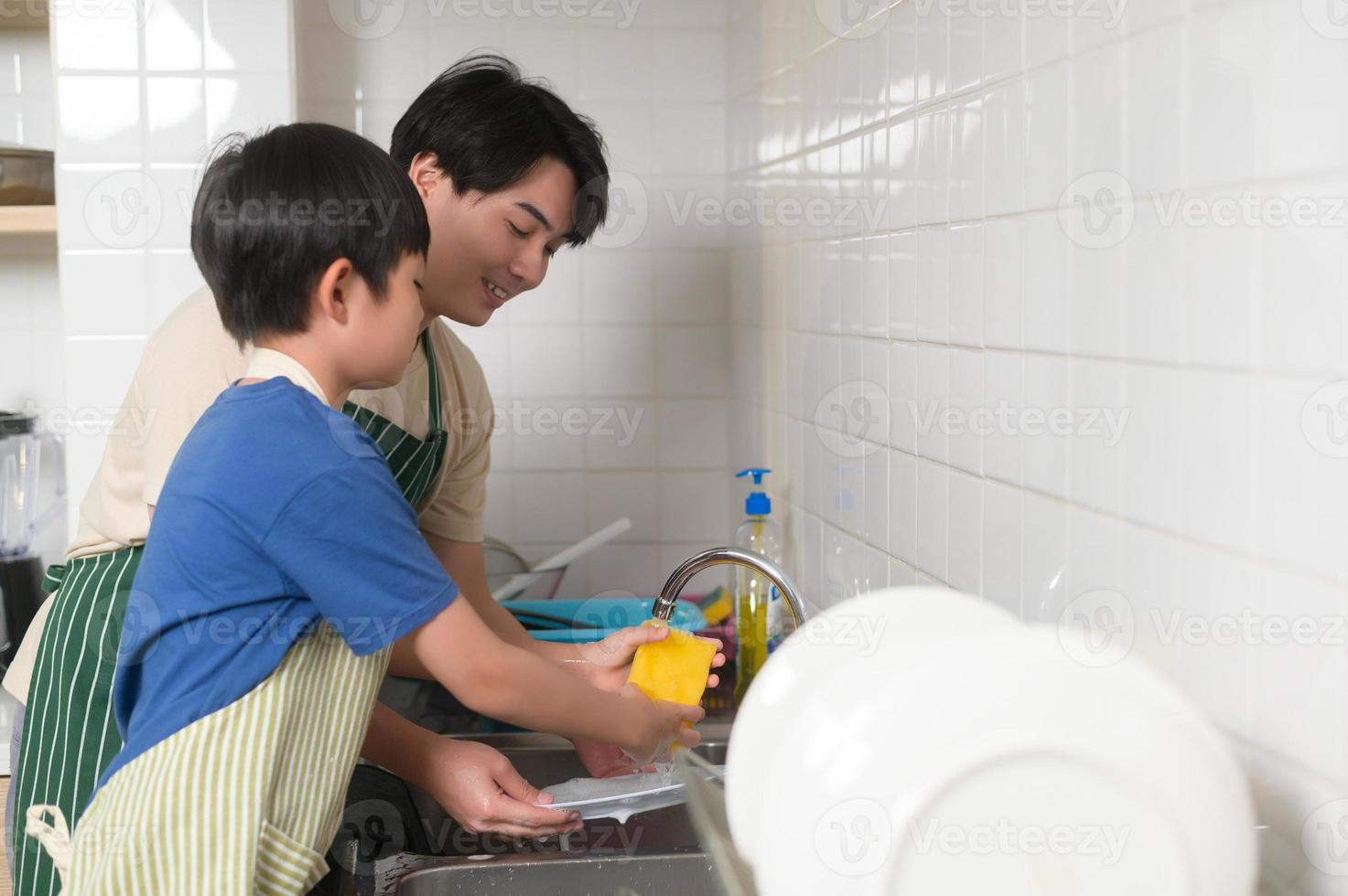 contento sonriente joven asiático padre y hijo Lavado platos en cocina a hogar foto