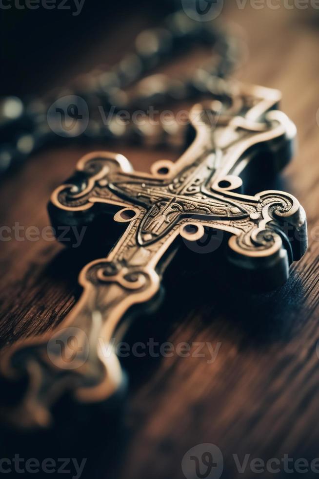 Close-up of a silver cross on a wooden table, shallow depth of field photo