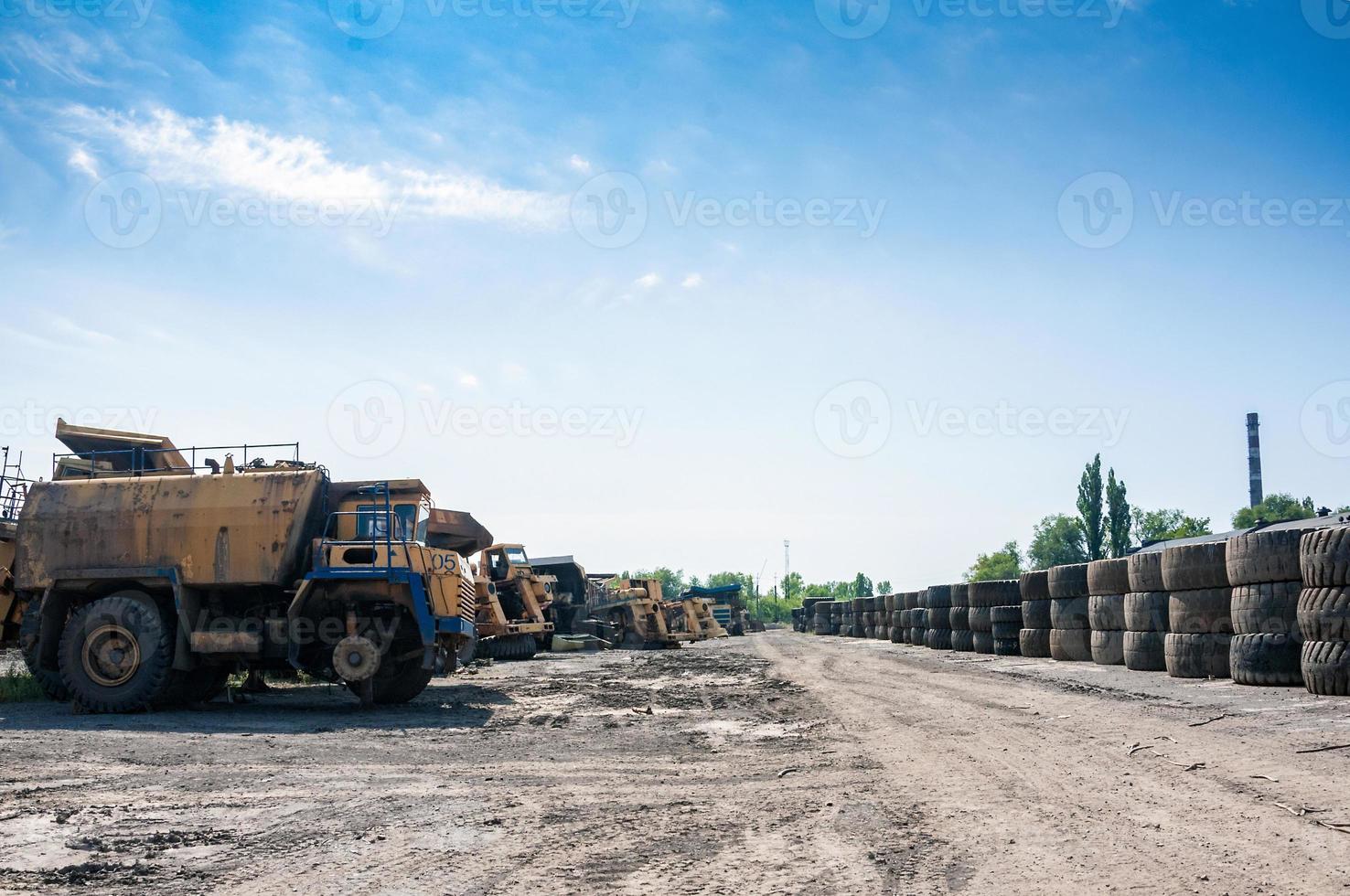 stack of an old quarry truck tires on industrial waste ground at sunny day photo