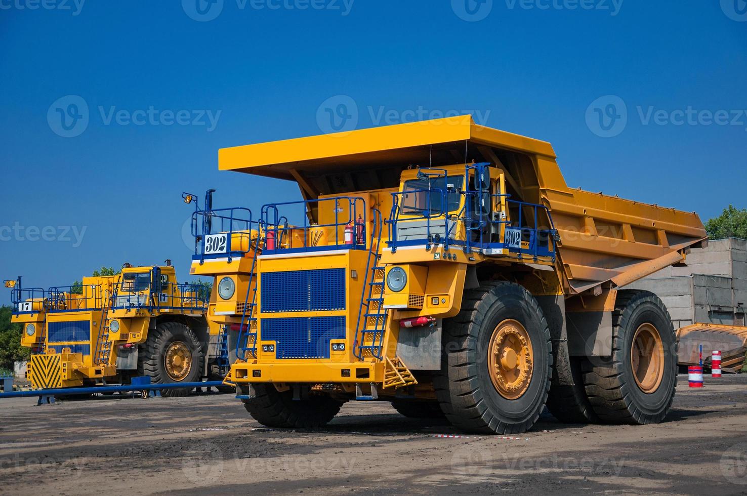 Quarry yellow dump truck drives alone industrial area at sunny day photo